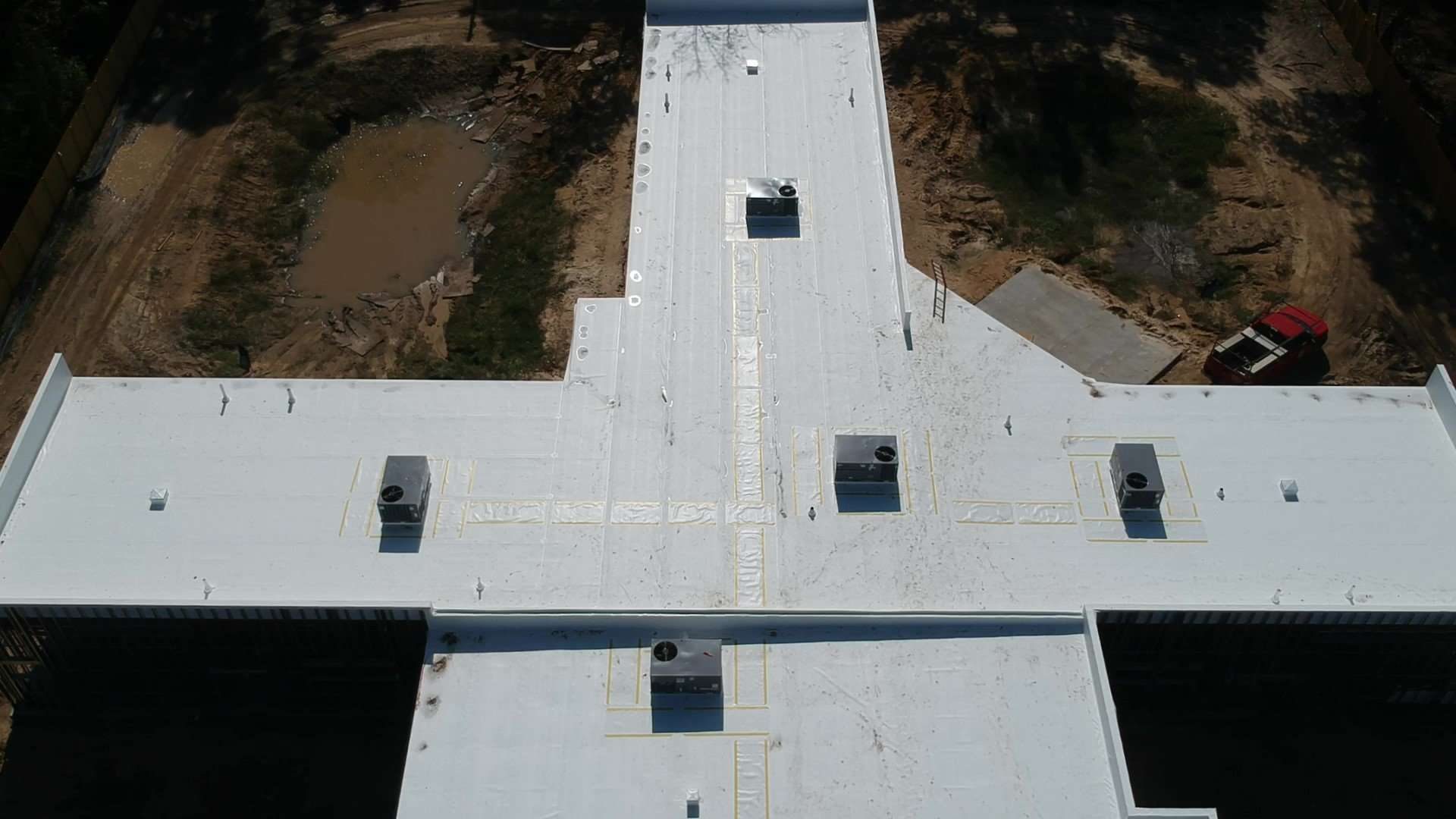 Aerial view of a finished white TPO single-ply roof with walk pads installed by RPI Roofing